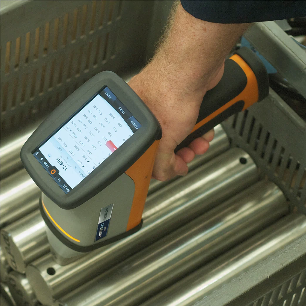 Handheld XRF-analyseapparaat bij metalen rondstaven